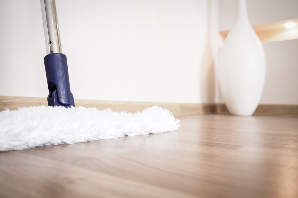 Service of cleaning hardwood floor from dust with white mop in house